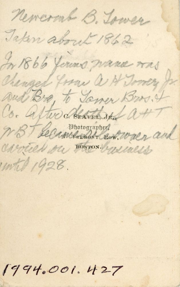 Back of photo of a young Newcomb with cursive handwriting