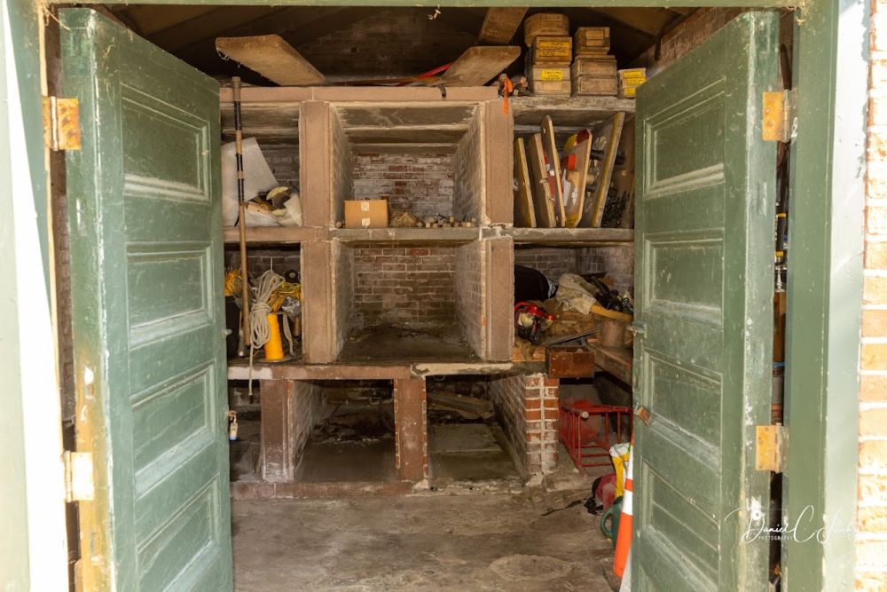 Interior of shed with 6 shelves to hold caskets in preparation for burial